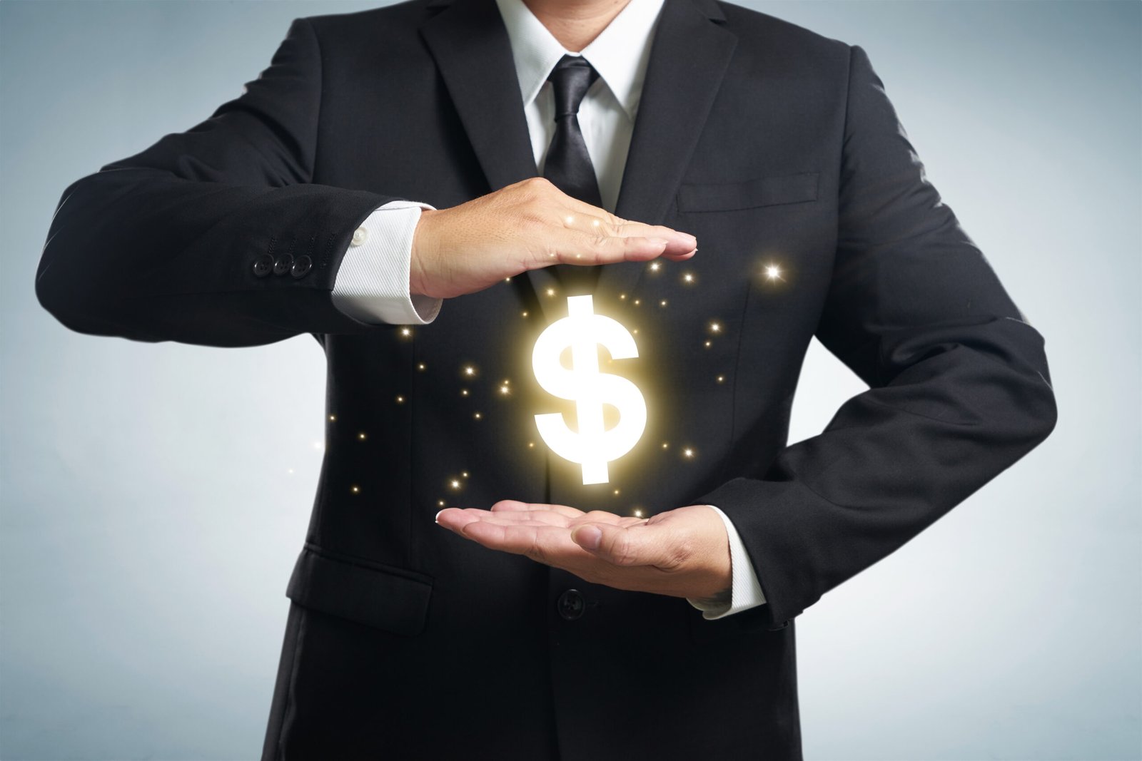 A person in a black suit is holding a glowing dollar sign between their hands, symbolizing financial protection or growth for new LLC owners, on a light gray background.